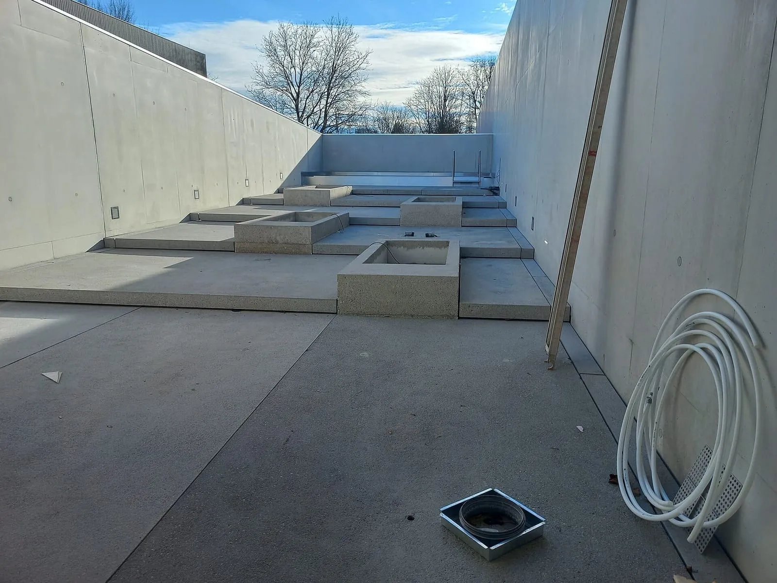 Concrete basins of a wet area under construction, outdoors, between concrete walls at the Seebad in Bregenz
