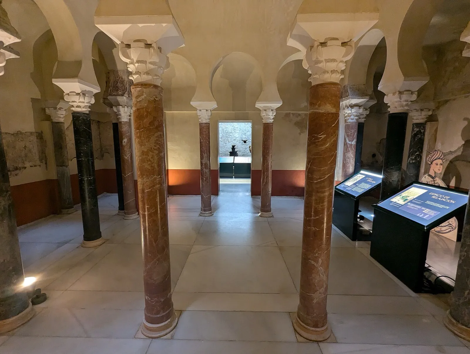Room of the Caliphal baths in Córdoba, with columns, horseshoe arches and museum panels