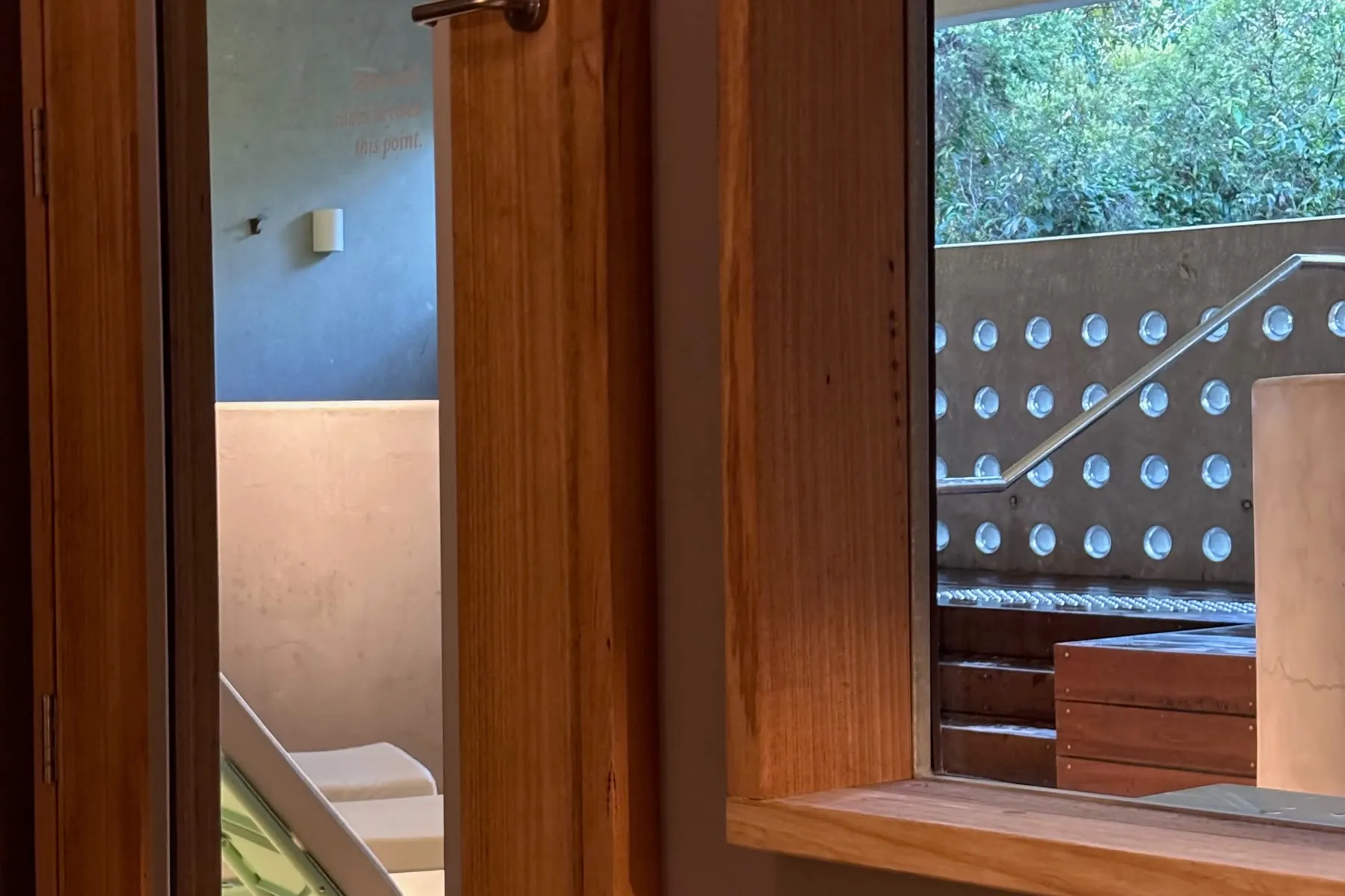 Timber window at Comma, looking out over the bathing area and the vegetation