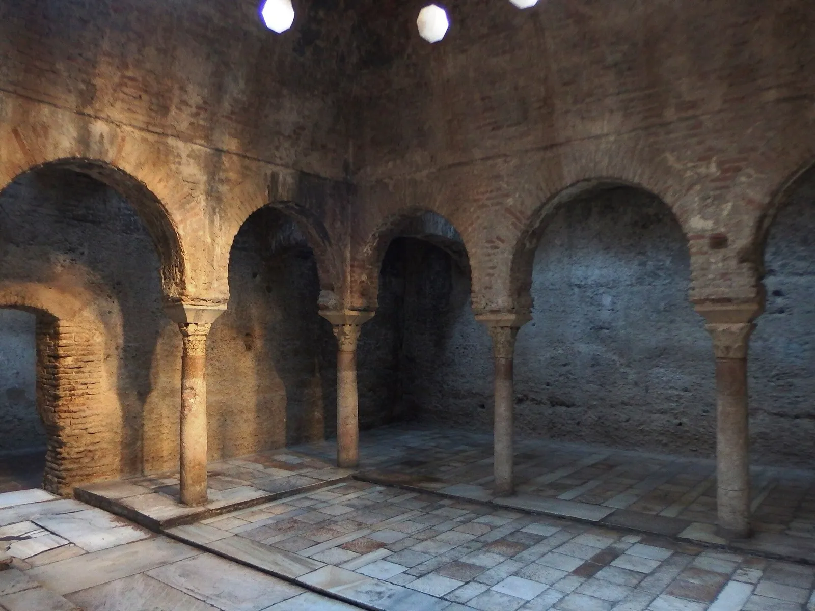 Warm room of the Bañuelo in Granada, with horseshoe arches on columns and a stone-slab floor
