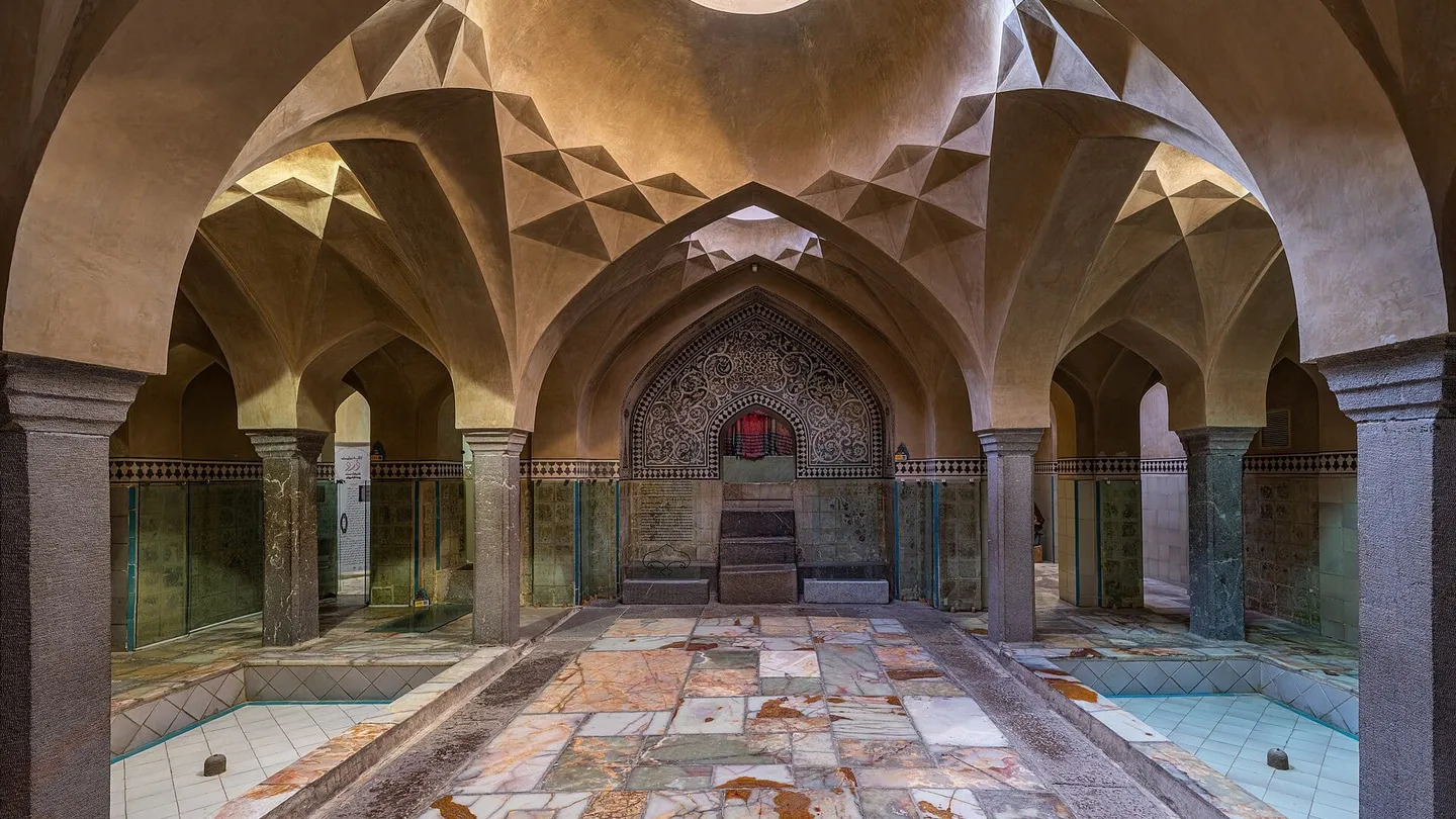 Vaulted hall of the Ali Gholi Agha hammam in Isfahan, with stone columns, arches and a central skylight