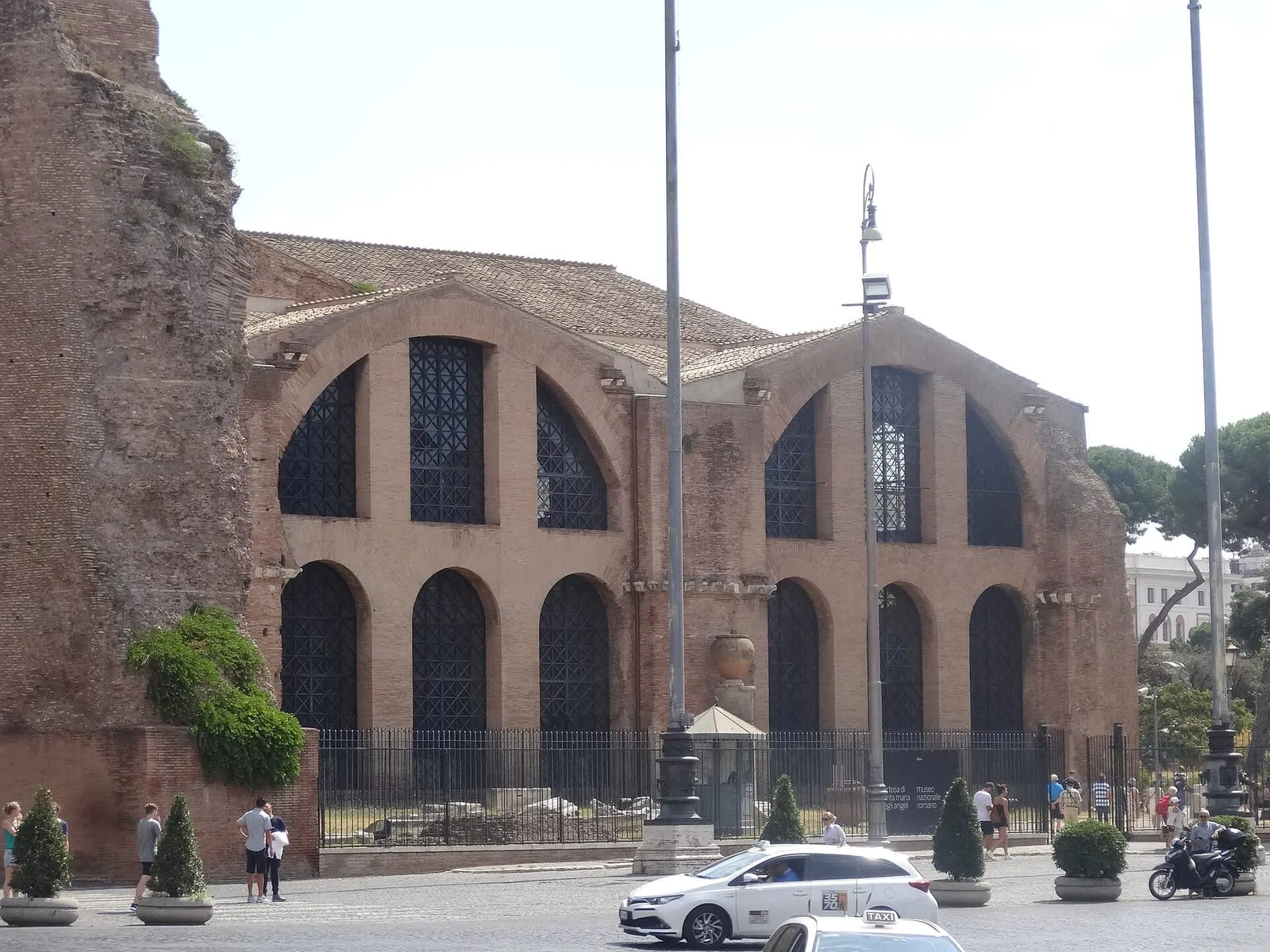 Brick facade of the Baths of Diocletian in Rome, now the basilica of Santa Maria degli Angeli, with large arched windows