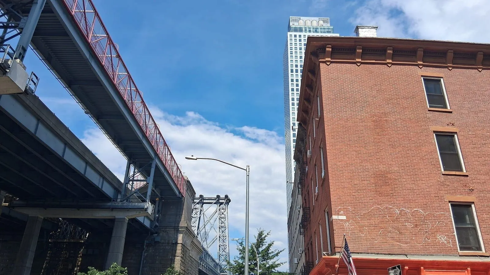 Street in Williamsburg, Brooklyn, with the Williamsburg Bridge behind and brick buildings